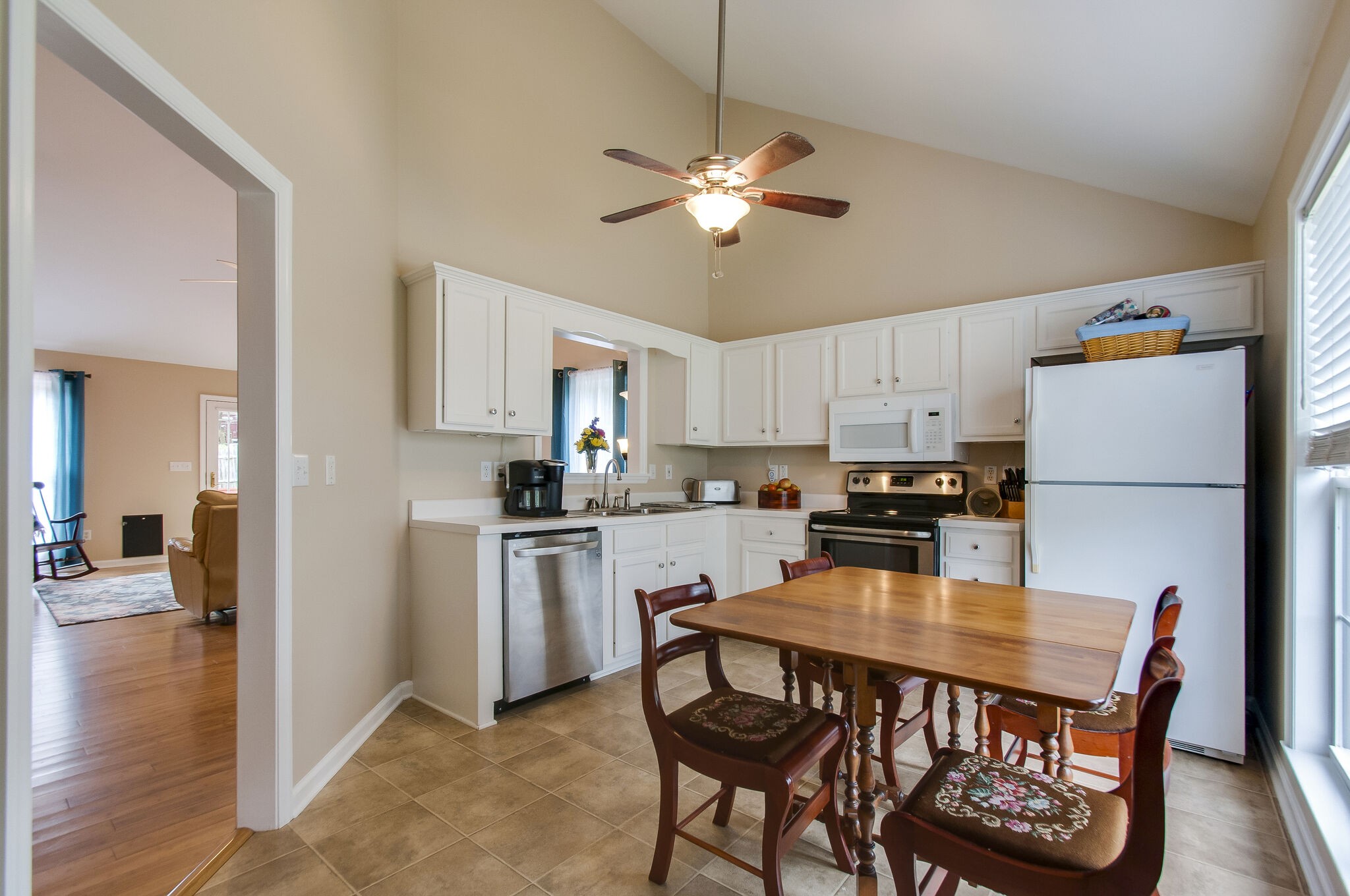 7487 Christopher Street Fairview, TN 37062 - Photo 15 of 27 a kitchen with a dining table chairs refrigerator and cabinets