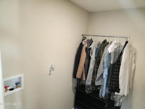 a view of walk in closet with clothes and shoes