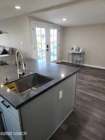 a kitchen with sink a counter space and wooden floor