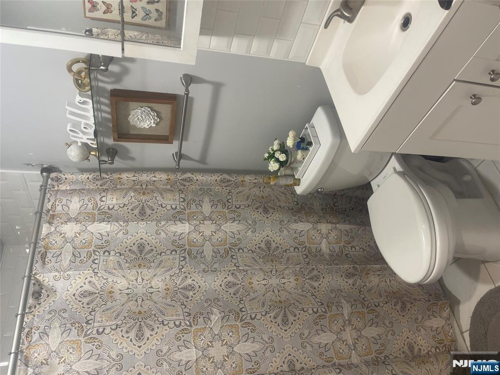 154 Butler Street Paterson, NJ 07524 - Photo 13 of 26 a bathroom with a sink mirror and toilet
