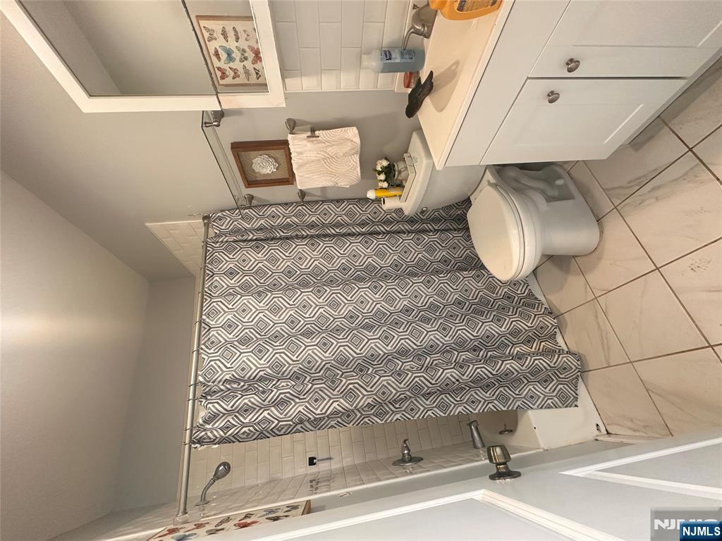 154 Butler Street Paterson, NJ 07524 - Photo 16 of 26 a bathroom with a granite countertop sink toilet and shower