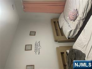 154 Butler Street Paterson, NJ 07524 - Photo 6 of 26 a bedroom with a bed and a window