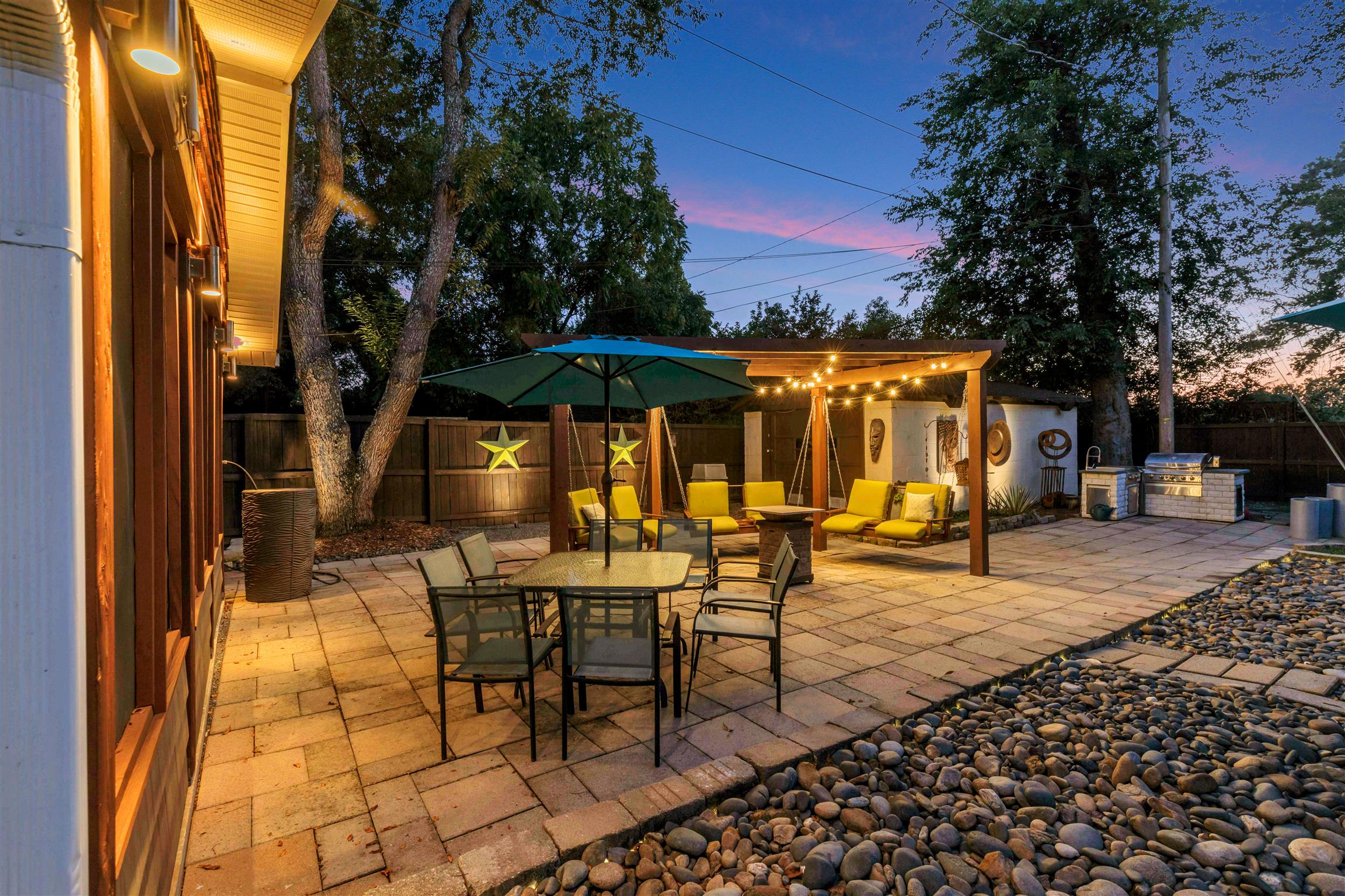 255 Cherokee Road Nashville, TN 37205 - Photo 30 of 30 a view of a patio with a table and chairs under an umbrella with barbeque grill and wooden fence