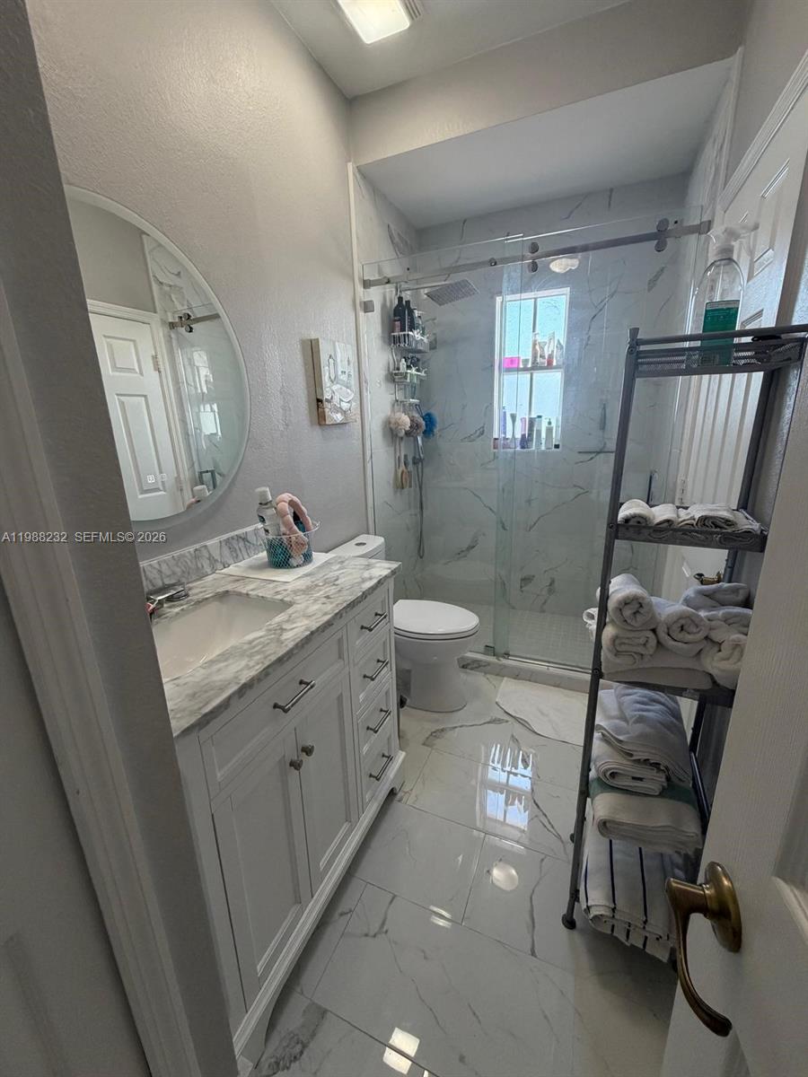 10837 Southwest 242nd Street Homestead, FL 33032 - Photo 10 of 19 a bathroom with a double vanity sink toilet and shower
