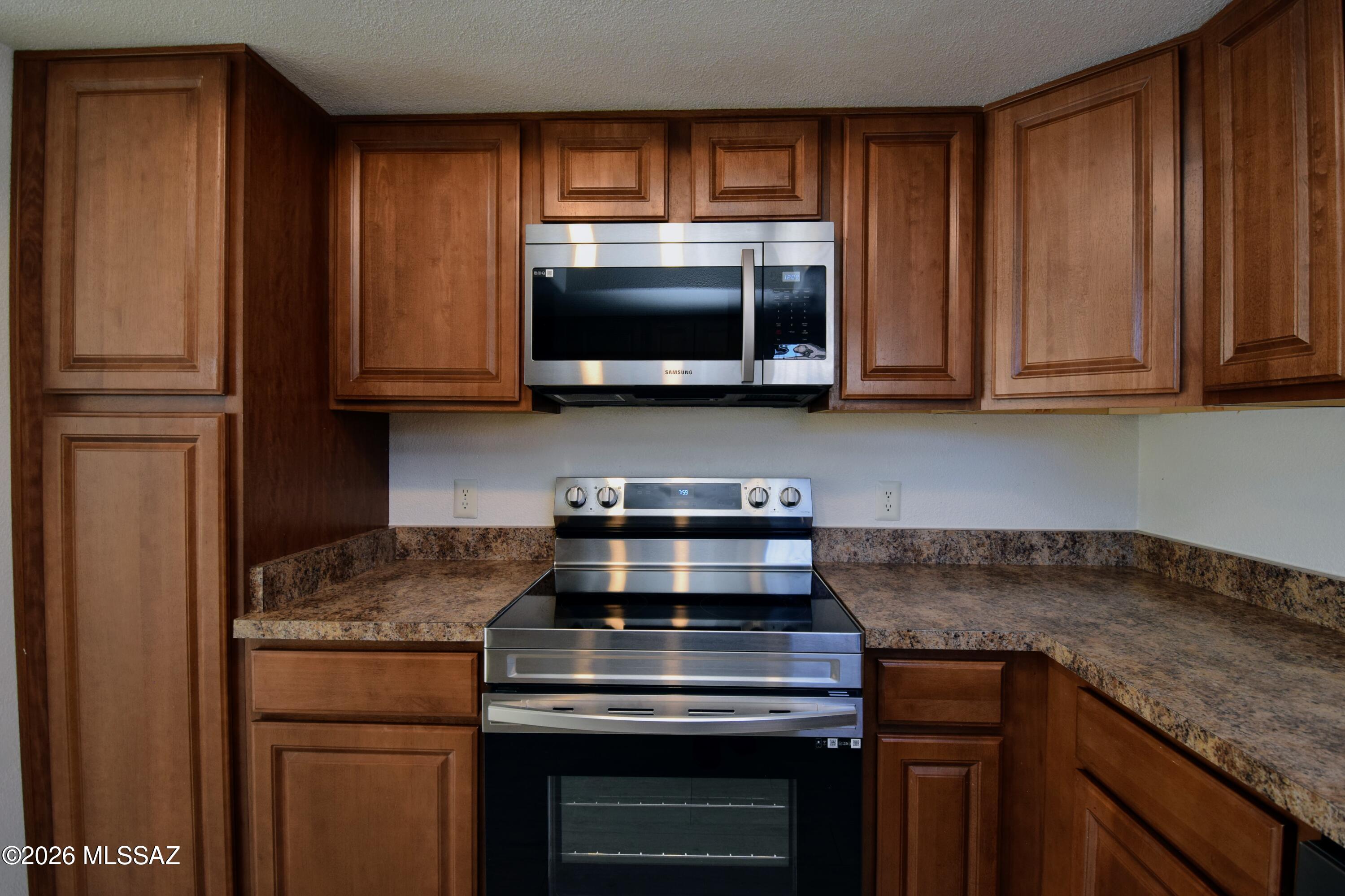 5855 North Kolb Road, Unit 11106 Tucson, AZ 85750 - Photo 15 of 36 a kitchen with granite countertop a stove and a microwave