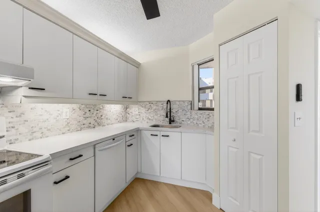 a kitchen with granite countertop white cabinets and sink