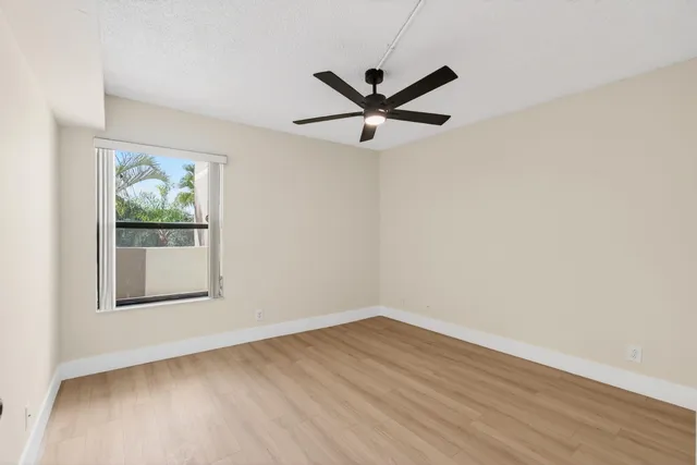 a view of an empty room with wooden floor and closet