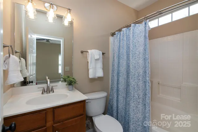 a bathroom with a sink vanity mirror and toilet