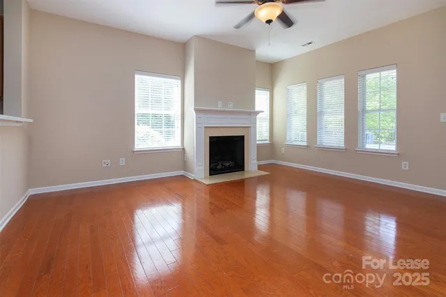 wooden floor fireplace and windows in an empty room
