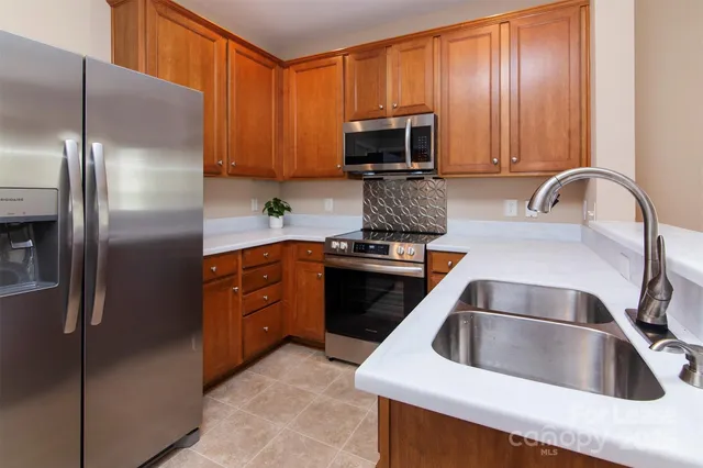 a kitchen with a refrigerator sink and cabinets