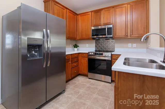a kitchen with stainless steel appliances granite countertop a stove a refrigerator and a sink