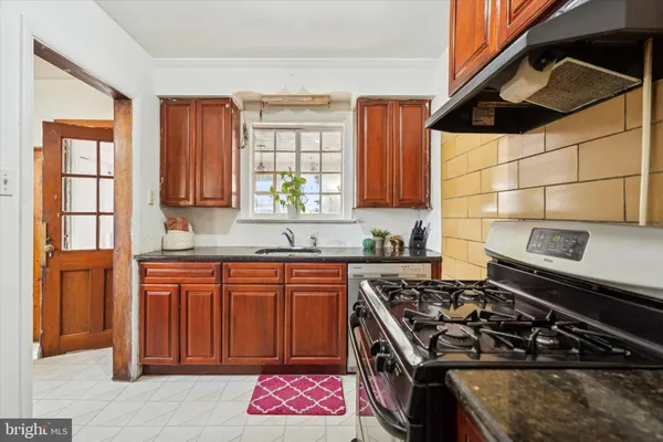 a kitchen with stainless steel appliances granite countertop a stove a sink dishwasher and cabinets with wooden floor