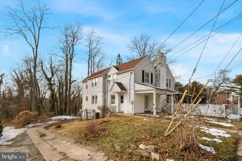 a view of a white house with a yard covered in snow
