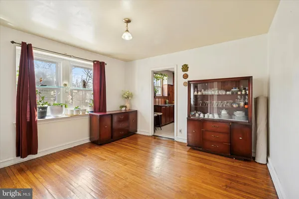 a large living room with a window and wooden floor