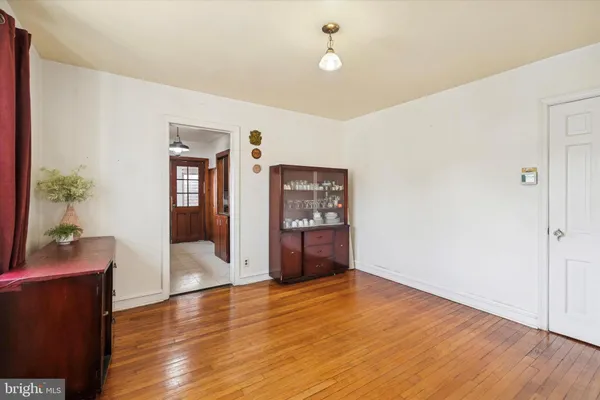 a view of an empty room with wooden floor and cabinet