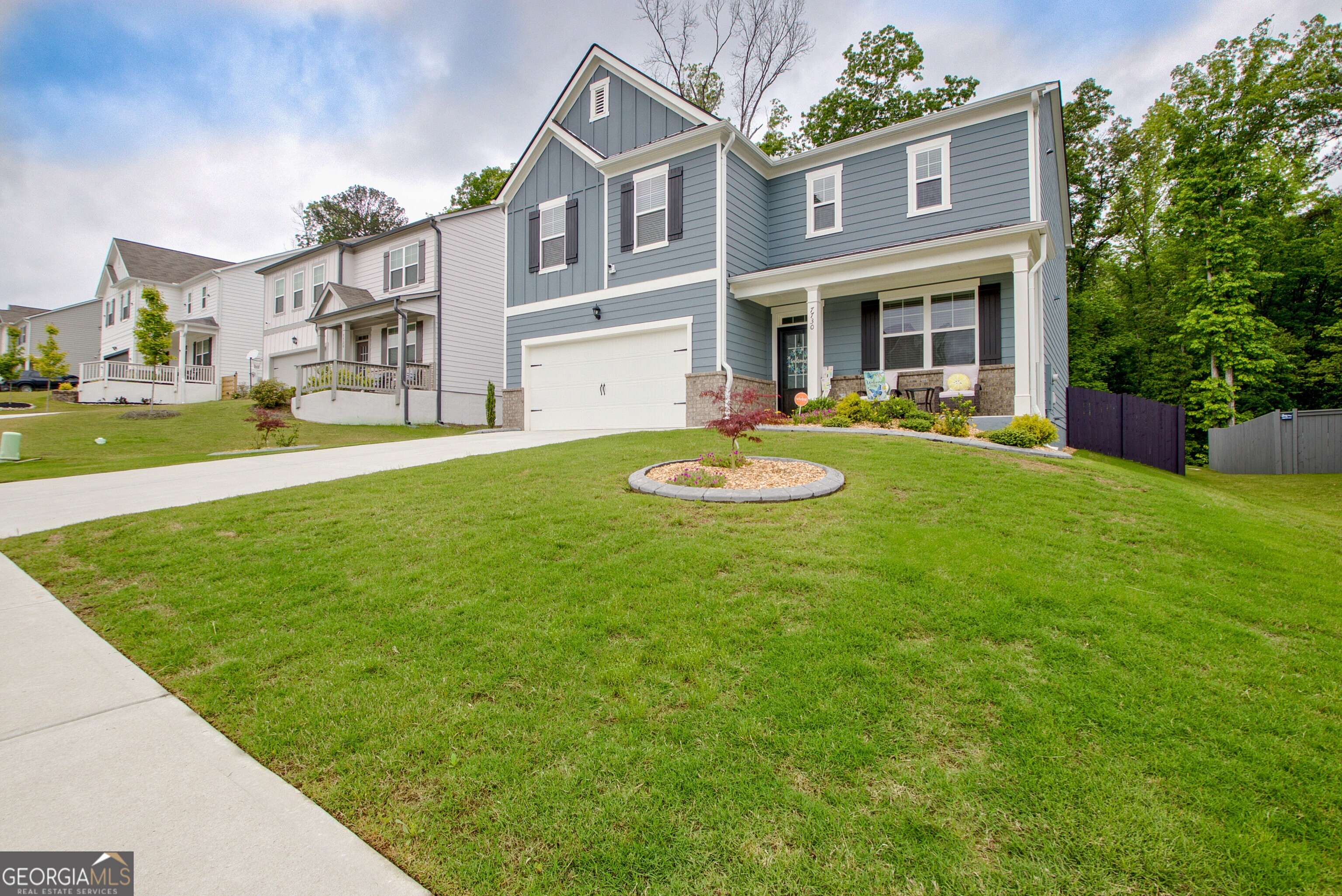 7730 Demeter Drive Fairburn, GA 30213 - Photo 2 of 47 a front view of a house with a yard table and chairs