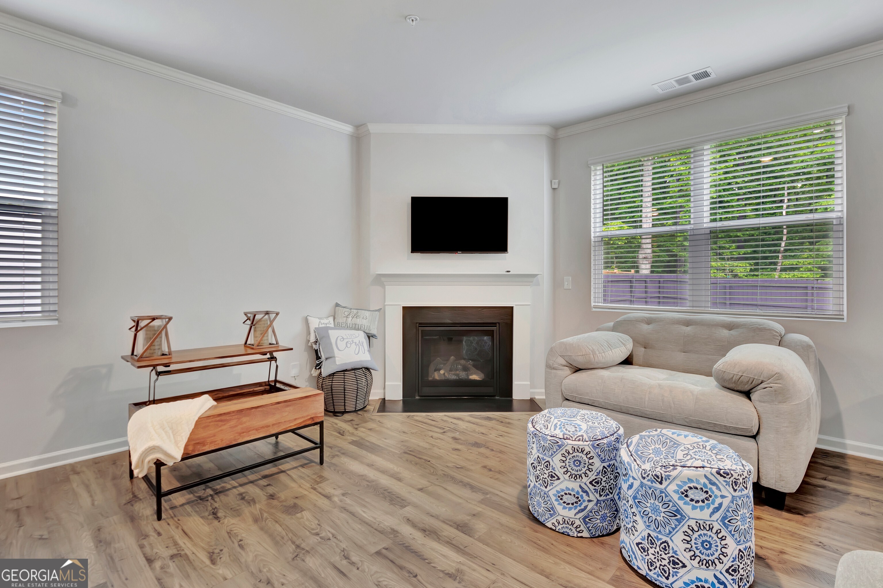7730 Demeter Drive Fairburn, GA 30213 - Photo 24 of 47 a living room with furniture a flat screen tv and a fireplace