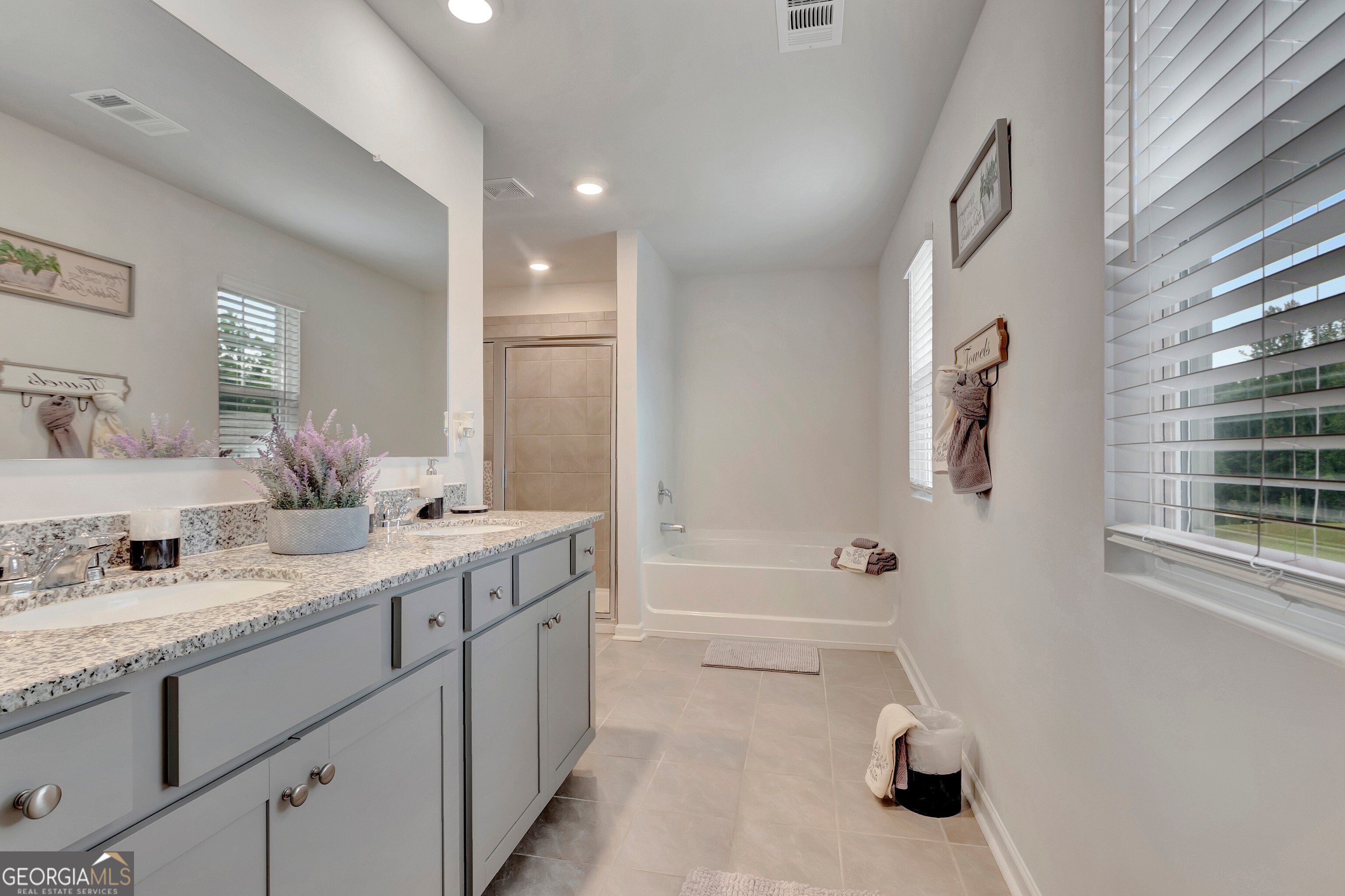 7730 Demeter Drive Fairburn, GA 30213 - Photo 34 of 47 a spacious bathroom with a sink double vanity granite tub shower and a mirror