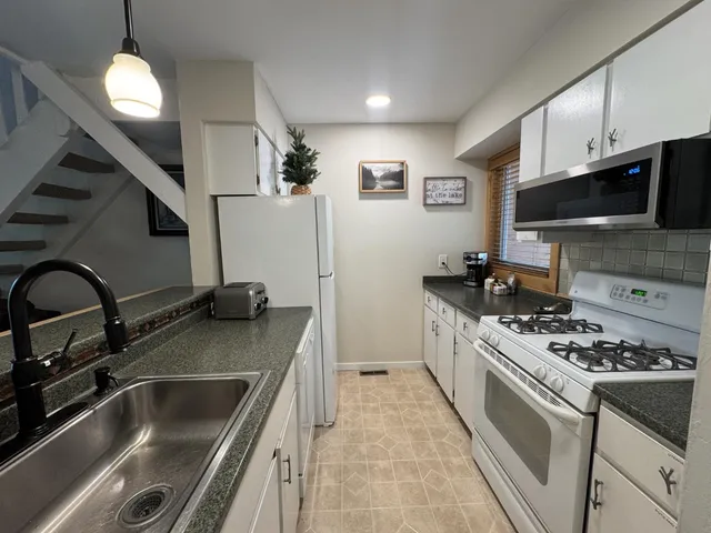 a kitchen with stainless steel appliances a sink a stove cabinets and a kitchen island