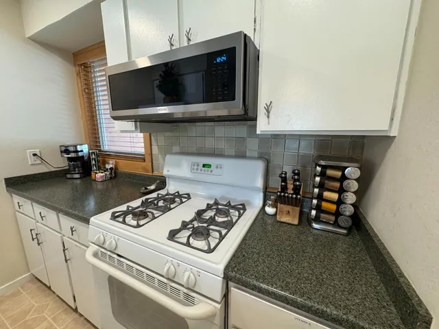 a kitchen with a stove a microwave and cabinets