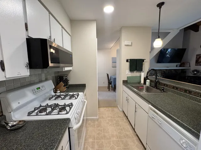 a kitchen with a sink a stove and a microwave