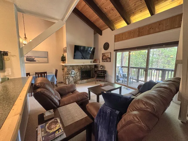 a living room with fireplace furniture and a large window