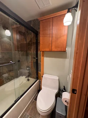 a white toilet sitting next to a bathtub