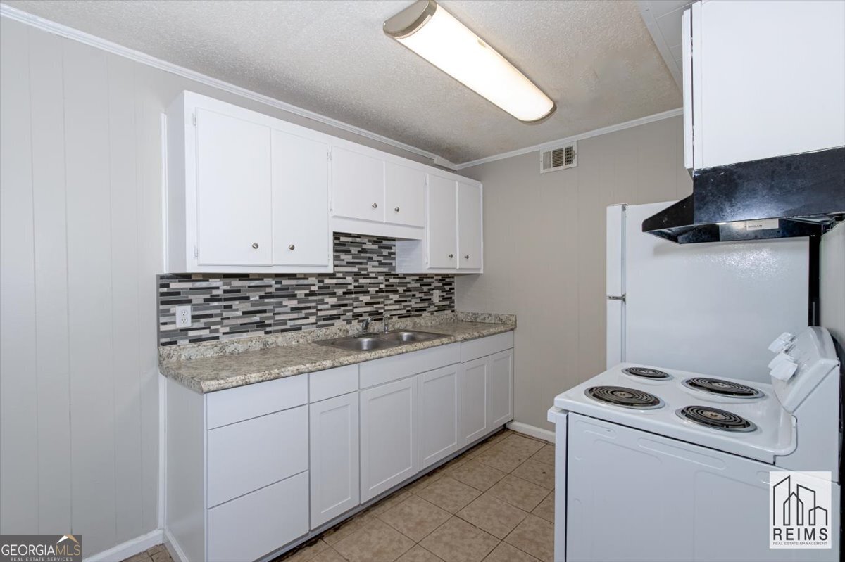 1232 12th Street, Unit F Augusta, GA 30901 - Photo 17 of 27 a kitchen with a stove and a sink