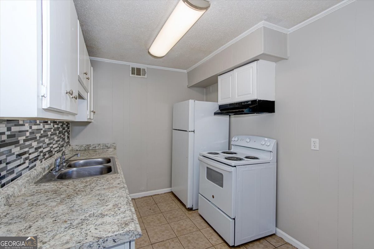1232 12th Street, Unit F Augusta, GA 30901 - Photo 6 of 27 a kitchen with appliances and cabinets