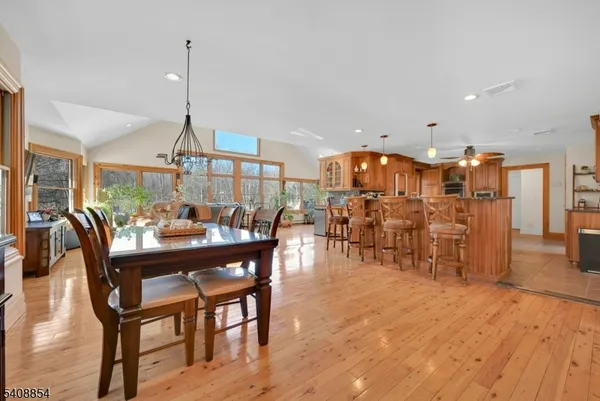 a view of a dining room and livingroom with furniture wooden floor a chandelier
