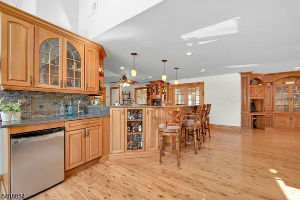 a dining hall with stainless steel appliances kitchen island granite countertop a dining table chairs and view living room