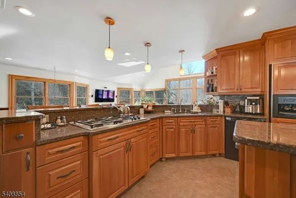 a kitchen with stainless steel appliances granite countertop a sink a stove and a refrigerator