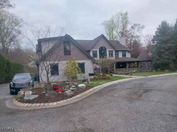 a front view of a house with a yard and fountain