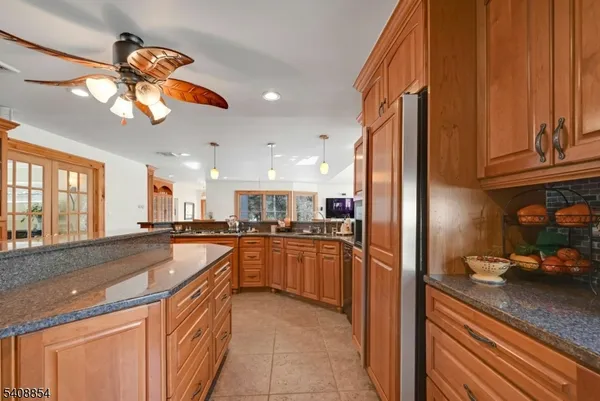 a kitchen with stainless steel appliances granite countertop a sink a stove and a refrigerator
