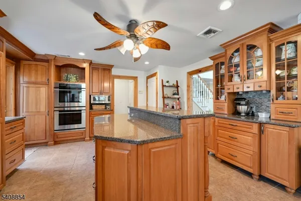 a kitchen with stainless steel appliances granite countertop a refrigerator and a stove