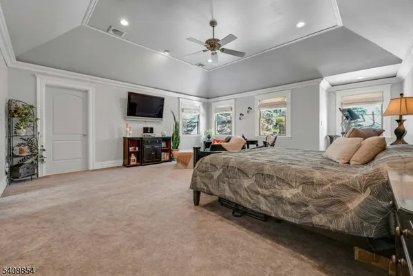 a spacious bedroom with a bed and a flat screen tv