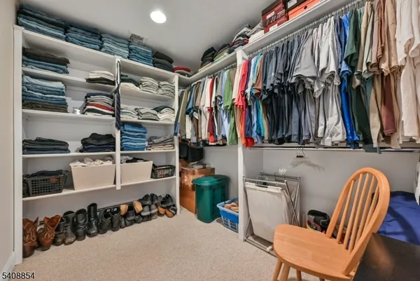 a view of walk in closet with clothes and shoes