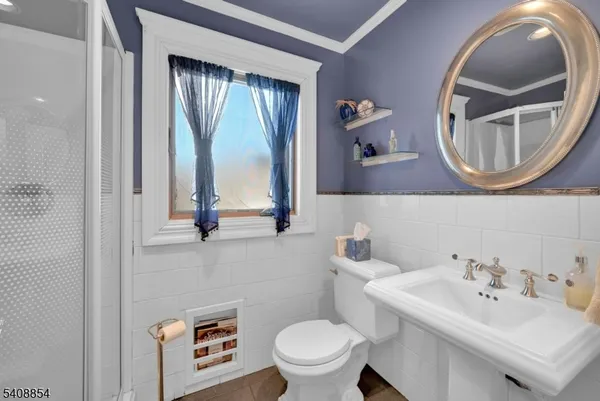 a bathroom with a toilet a sink and mirror