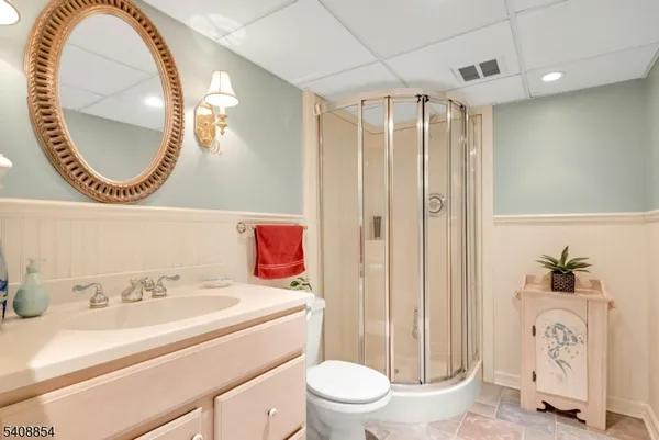 a bathroom with a sink a mirror a toilet and a shower