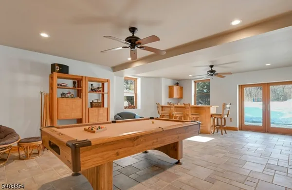 a living room with furniture pool table and a large window