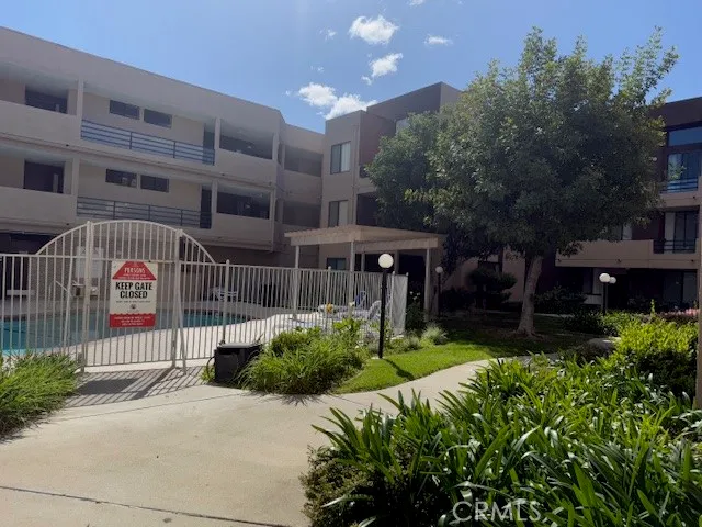 a view of a house with a yard and large trees