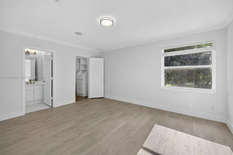a view of an empty room with closet and a window
