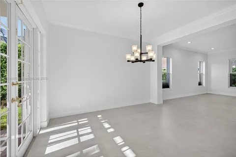 a view of a room with a chandelier fan and windows