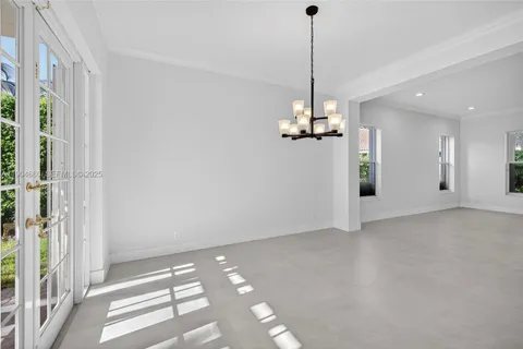 a view of a room with a chandelier fan and windows