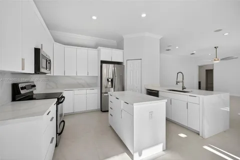 a kitchen with white cabinets and white appliances