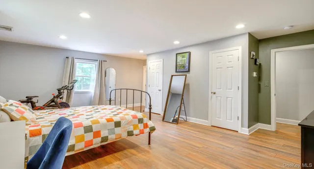 a bedroom with a bed and wooden floor