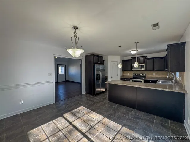a large kitchen with stainless steel appliances kitchen island granite countertop a sink and cabinets