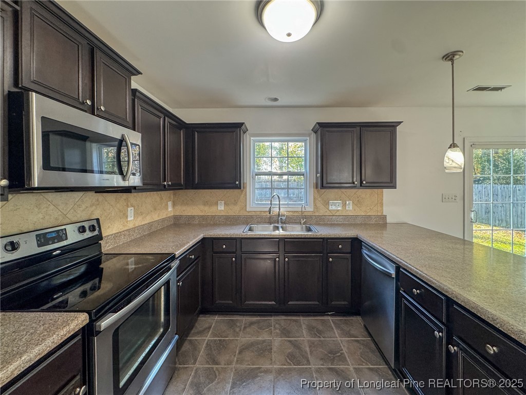142 Crestwood Lane Raeford, NC 28376 - Photo 14 of 30 a kitchen with stainless steel appliances granite countertop sink stove top oven and microwave