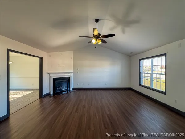 a view of an empty room with a fireplace and a window