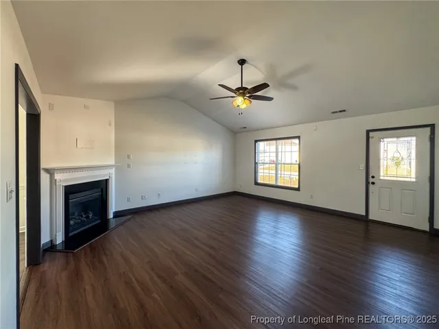 an empty room with wooden floor and fireplace